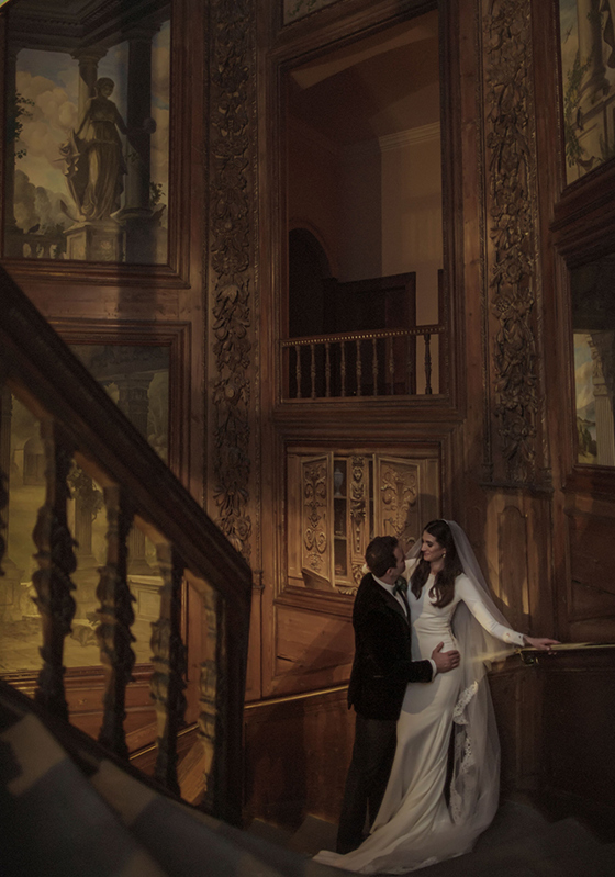 Moody, darkened image of bride and groom on stairs